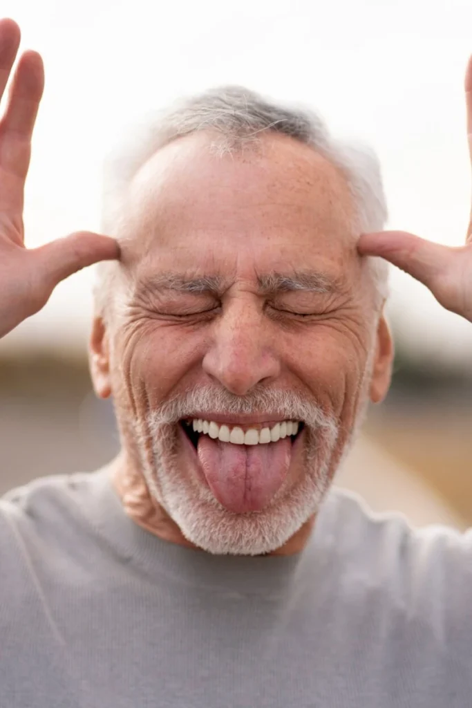 Portrait älterer Mann, streckt die Zunge heraus